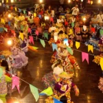 Grupo dançando quadrilha sob decoração de bandeirinhas