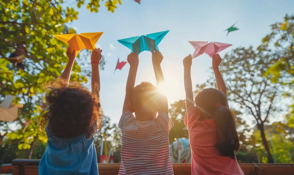 Crianças brincando no dia das Crianças com origamis em parque