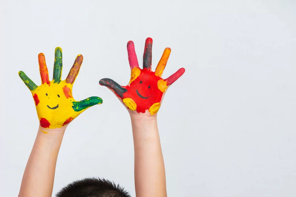 Crianças com as mãos pintadas coloridas em fundo branco