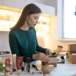 Mulher empacotando produtos que serão vendidos em loja do e-commerce