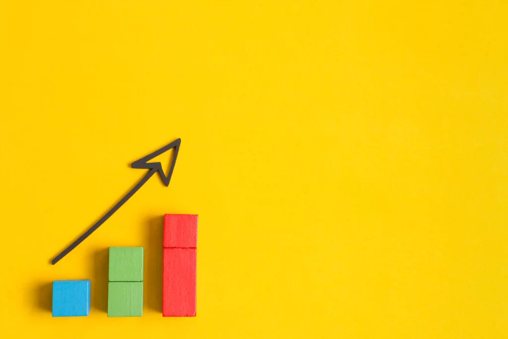 Gráficos coloridos de aumento com uma seta preta em cima em fundo amarelo