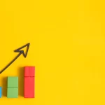 Gráficos coloridos de aumento com uma seta preta em cima em fundo amarelo