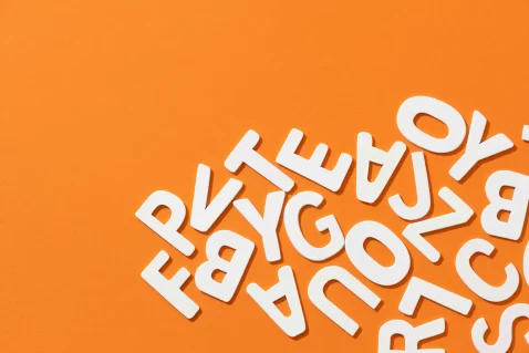 Fundo laranja com diversas letras brancas embaralhadas