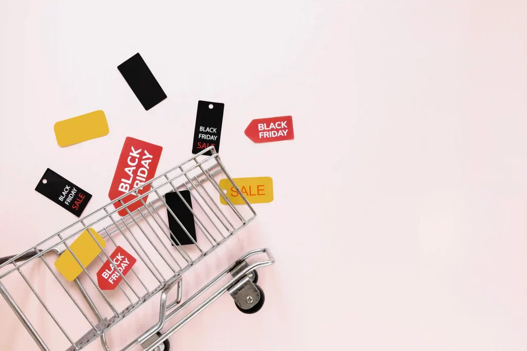 Carrinho de compras com várias tags da Black Friday em volta em fundo branco