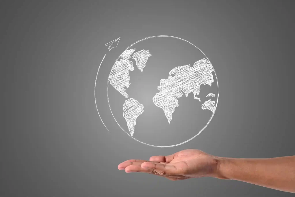 Desenho do planeta terra em um quadro negro com uma mão de homem logo abaixo