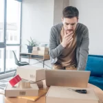 Homem em frente a computador em loja tentando entender o que aconteceu com suas vendas