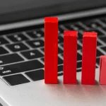 Gráfico vermelho de queda sobre um notebook cinza