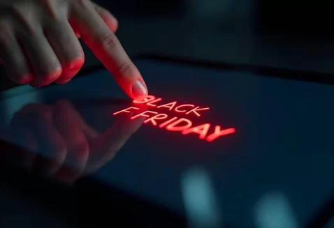 Dedo toca tela digital iluminada com as palavras “Black Friday” em vermelho brilhante