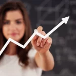 Mulher desfocada ao fundo destacando um gráfico de linha crescente em primeiro plano, simbolizando aumento de vendas no varejo