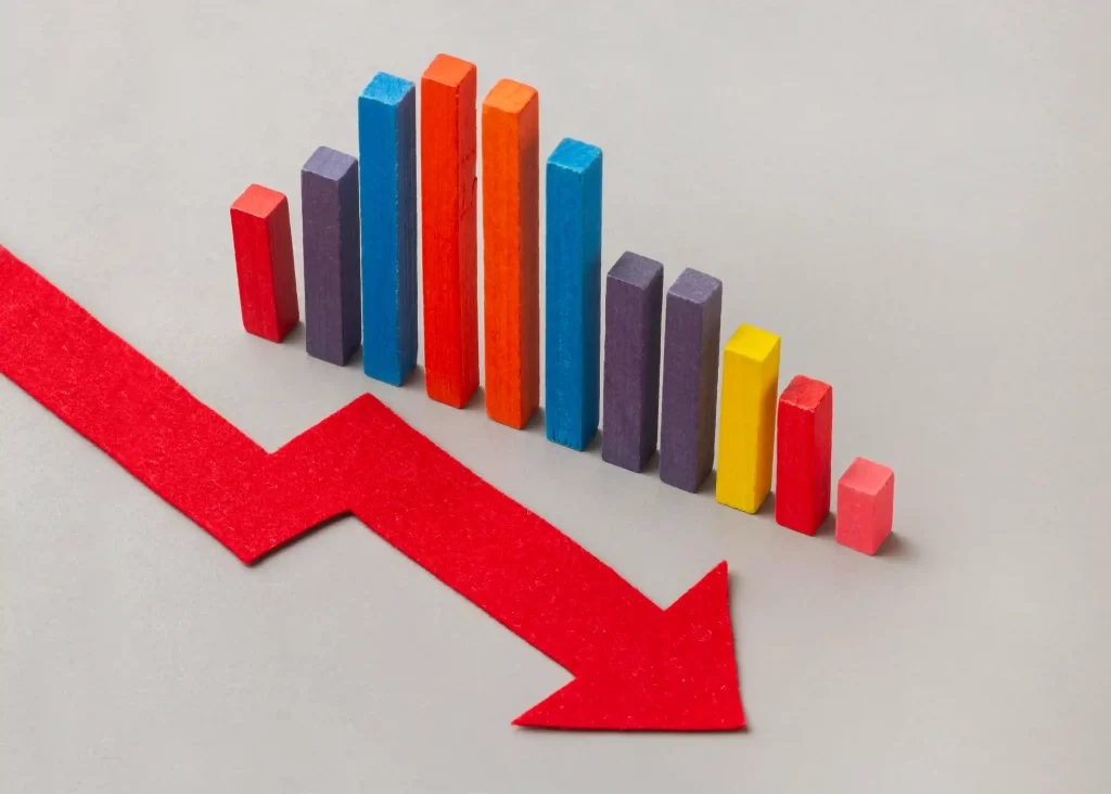 Gráfico de barras coloridas com seta vermelha em queda, representando alerta de baixa nos preços