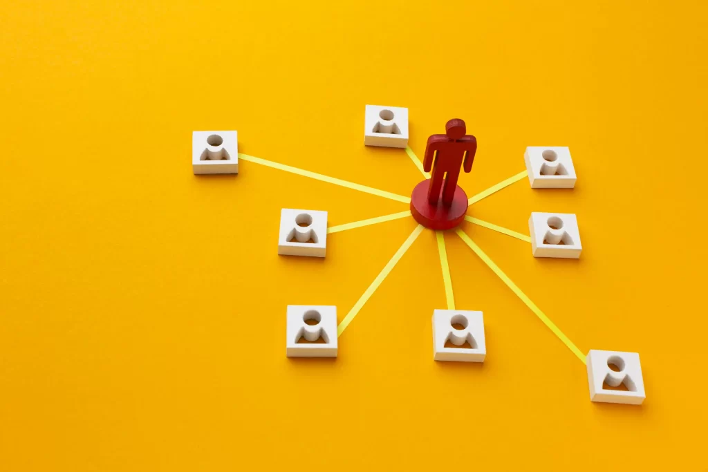 Peça vermelha em forma de pessoa conectada a várias miniaturas brancas por linhas amarelas sobre fundo amarelo, representando a rede de clientes recorrentes