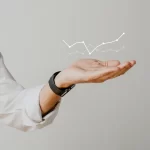 Mão masculina sustentando um gráfico ascendente digital, simbolizando o crescimento e o acompanhamento de microtendências no mercado
