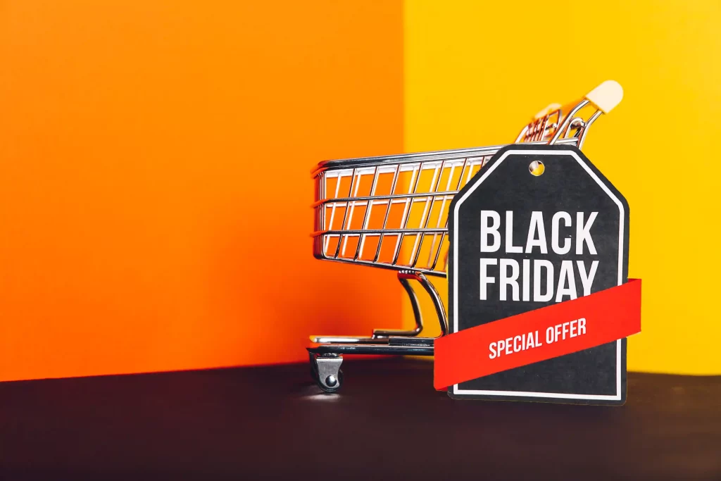 Mini carrinho de compras com etiqueta de “Black Friday – Special Offer” em fundo laranja e amarelo
