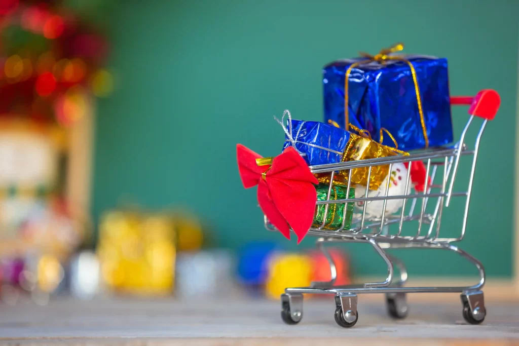 Carrinho de compras com presentes embrulhados, simbolizando o comportamento de compra no Natal 2025
