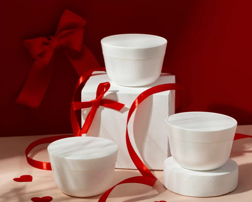 Embalagens de creme com laços vermelhos usadas em kits inteligentes de Natal 2025