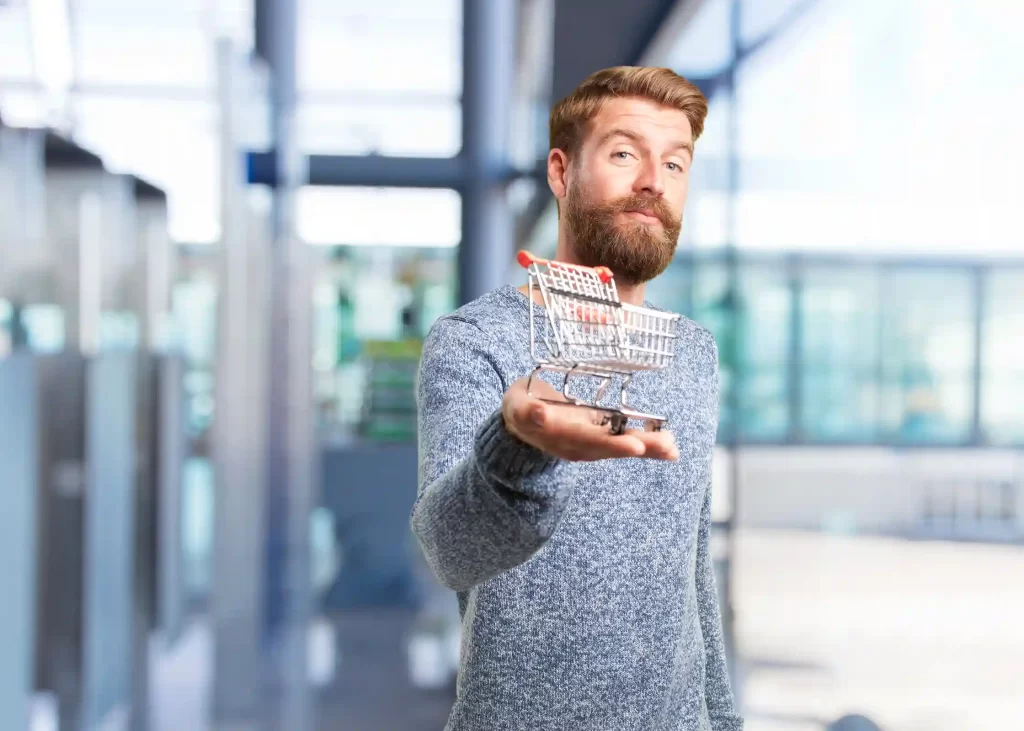 Homem segurando um carrinho de compras em ambiente corporativo, simbolizando planejamento de janeiro e como se antecipar nas decisões de vendas e e-commerce