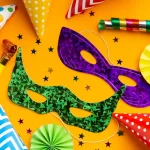 Conjunto de acessórios para Carnaval sobre fundo amarelo, com máscaras coloridas, chapéus de festa, apitos, confetes e serpentinas