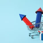 Carrinho de compras com dois foguetes coloridos dentro, representando aceleração das vendas e crescimento do e-commerce em um fundo azul claro