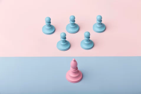 Peça de jogo no formato de peão rosa posicionada sozinha na parte inferior da imagem, enquanto cinco peões azuis estão agrupados na parte superior