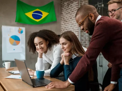Equipe analisando dados em notebook com bandeira do Brasil ao fundo, representando crescimento do marketplace no Brasil em 2026