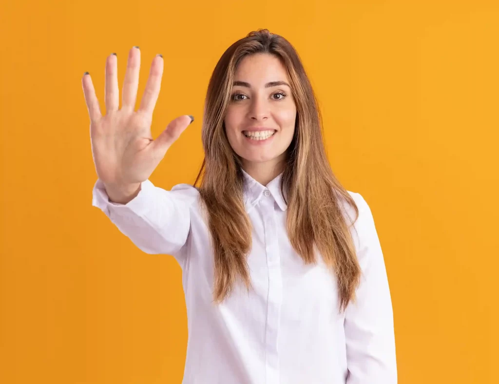 Mulher sorrindo com a mão aberta mostrando o número cinco, simbolizando cinco métricas de e-commerce essenciais antes do fechamento do mês
