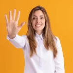 Mulher sorrindo com a mão aberta mostrando o número cinco, simbolizando cinco métricas de e-commerce essenciais antes do fechamento do mês