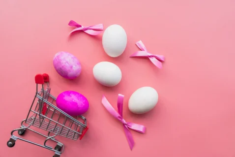 Ovos de Páscoa ao lado de carrinho de compras, representando transição para novos produtos com alta demanda após a data sazonal
