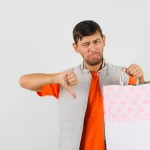 Homem segurando sacola de compras e fazendo sinal negativo com o polegar, representando erros internos que prejudicam o posicionamento no Mercado Livre