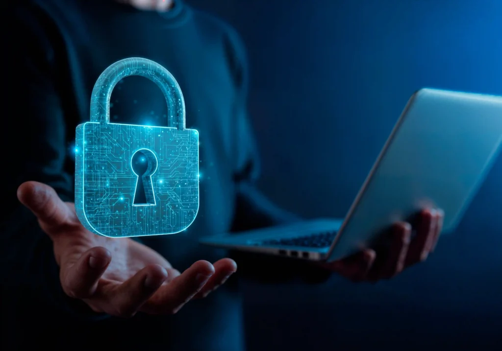 Cadeado digital holográfico sendo segurado por pessoa com notebook, representando segurança de dados e proteção no e-commerce