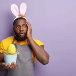 Vendedor com orelhas de coelho segurando ovo de Páscoa com expressão de surpresa, representando oportunidade de vendas na Páscoa 2026