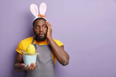 Vendedor com orelhas de coelho segurando ovo de Páscoa com expressão de surpresa, representando oportunidade de vendas na Páscoa 2026