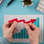 Mãos segurando seta vermelha irregular sobre gráfico de barras, ilustrando a desaceleração no crescimento do e-commerce e a nova fase do mercado