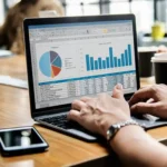 Laptop exibindo planilha com gráficos de despesas e categorias, simbolizando uso de dados para otimizar vendas