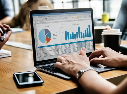 Laptop exibindo planilha com gráficos de despesas e categorias, simbolizando uso de dados para otimizar vendas