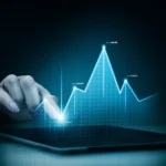 Mão interagindo com tablet exibindo gráfico digital azul com dados financeiros e tendências de crescimento