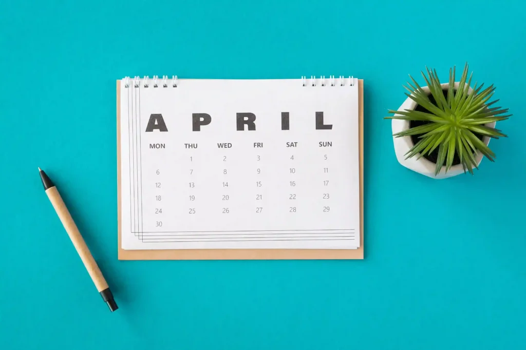 Calendário do mês de abril com itens de escritório, representando planejamento estratégico de vendas no e-commerce após a Páscoa.