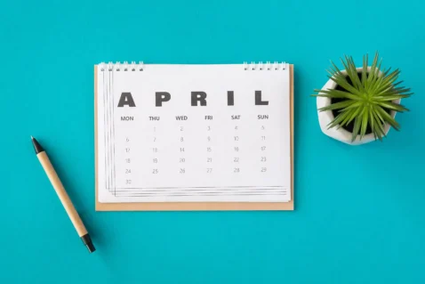 Calendário do mês de abril com itens de escritório, representando planejamento estratégico de vendas no e-commerce após a Páscoa.