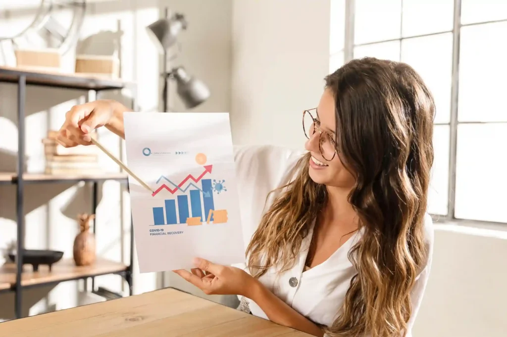 Profissional analisando gráfico de recuperação financeira com barras e linha ascendente, simbolizando consistência nas vendas