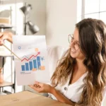 Profissional analisando gráfico de recuperação financeira com barras e linha ascendente, simbolizando consistência nas vendas