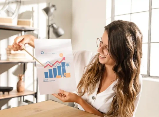 Profissional analisando gráfico de recuperação financeira com barras e linha ascendente, simbolizando consistência nas vendas