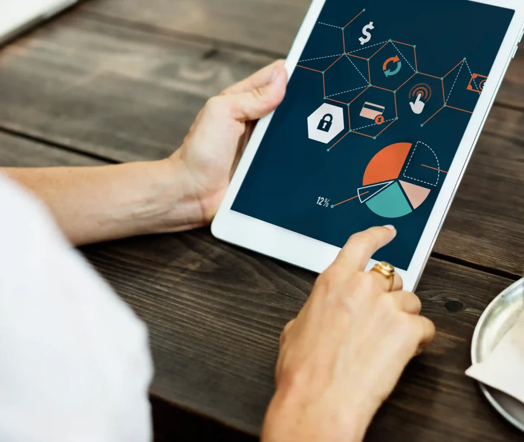 Pessoa analisando gráfico de pizza e métricas financeiras em tablet, ilustrando a leitura de visitas e conversão por anúncio na análise pós Dia das Mães no Mercado Livre