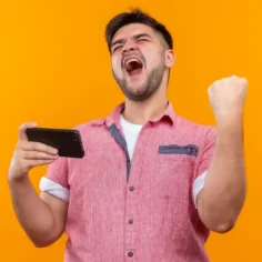 Homem empolgado comemorando com smartphone na mão, representando o comportamento de compras pelo celular durante a Copa 2026 e a oportunidade de vender pelo mobile no Mercado Livre