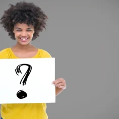 Mulher sorrindo segurando placa com ponto de interrogação, ilustrando como responder perguntas de clientes no Mercado Livre e converter dúvidas em vendas