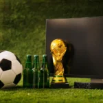 Troféu da Copa do Mundo, bola de futebol e garrafas de cerveja sobre grama, representando os produtos mais vendidos durante os jogos da Copa 2026