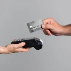 Mão aproximando cartão de crédito de maquininha de pagamento, ilustrando o parcelamento sem juros no Mercado Livre como estratégia para vender mais