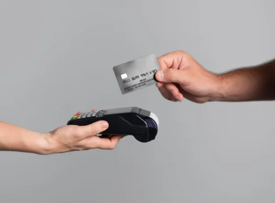 Mão aproximando cartão de crédito de maquininha de pagamento, ilustrando o parcelamento sem juros no Mercado Livre como estratégia para vender mais