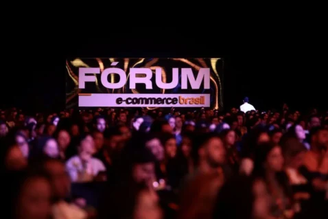 Público reunido em frente a telão com o logo do Fórum E-Commerce Brasil 2026 durante o evento