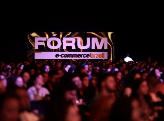 Público reunido em frente a telão com o logo do Fórum E-Commerce Brasil 2026 durante o evento