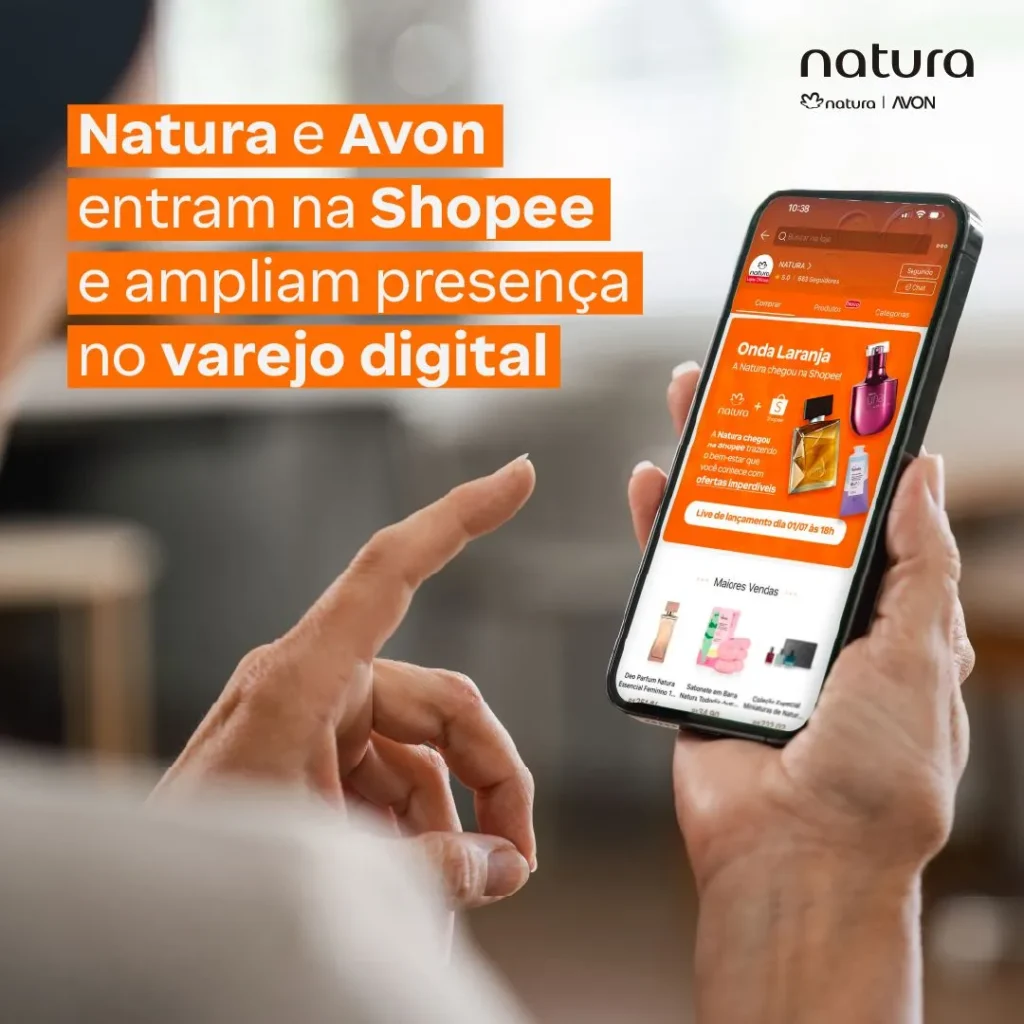 Divulgação Natura mostrando celular com a loja oficial da marca na Shopee, anunciando a chegada de Natura e Avon ao marketplace