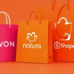 Sacolas de compra com as marcas Avon, Natura e Shopee lado a lado, simbolizando grandes marcas no marketplace